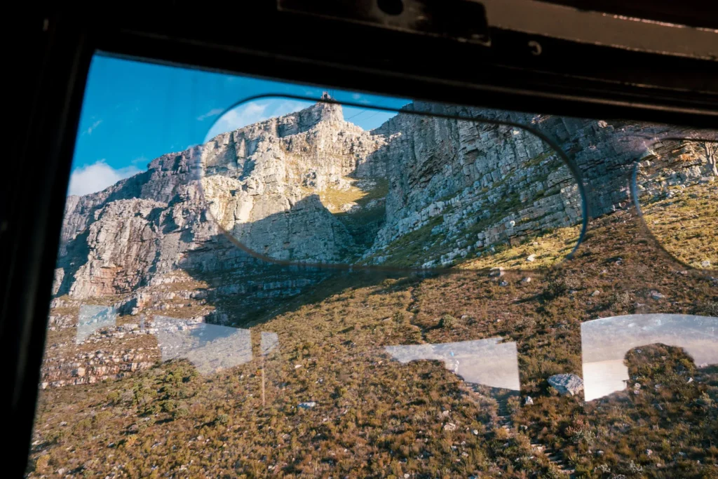 A close up image of a rugged mountain side from the window of a cable car