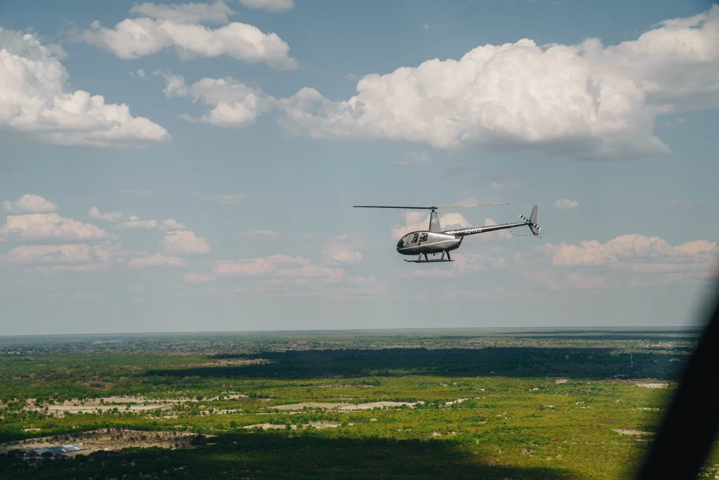 A helicopter soars above the Okavango Delta en route to Atzaró Okavango.