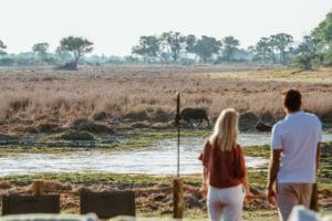 Couple on a terrace at Atzaró Okavango Camp enjoying wildlife views in Botswana.