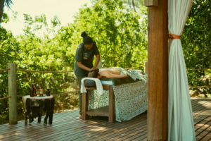 A woman having a spa treatment on the deck of Atzaró Okavango Camp.