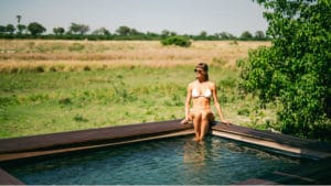 Hotel guest relaxing by the pool at Atzaro Okavango Camp