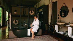 A guest relaxing in the suite at the Atzaro Okavango luxury camp in Botswana after a safari.